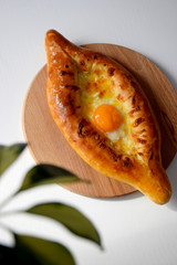 Just baked hot Georgian bread with egg yolk and cheese on wooden cutting board