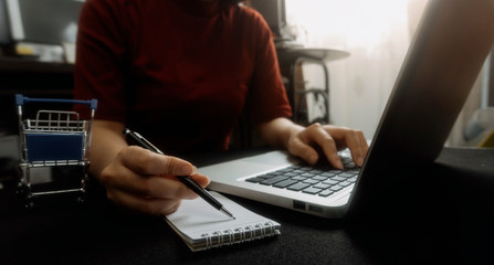 Businessman hands working with finances about cost and calculator and laptop with tablet, smartphone at office in morning light