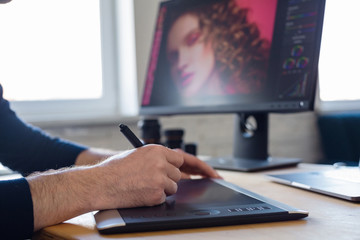 Retouching images in special program.Portrait of graphic designer working in office with...