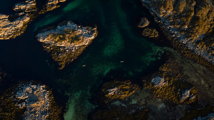 Aerial picture of kayaks between islands. Active summer vacation, north of norway located in lofoten islands. Two people kayaking surrounded beautiful landscape and turquoise sea. Distance 