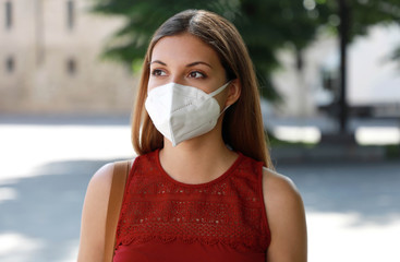 COVID-19 Worried girl in city street wearing KN95 FFP2 mask protective for spreading of disease...