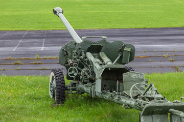 Old artillery gun stands on green grass