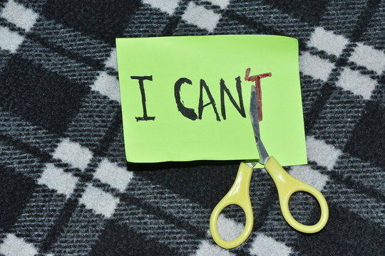 I can self motivation - cutting the letter 'T' of the written word I can't so it says I can, goal achievement, potential, overcoming.Mobile,Scissor in the black and white background.