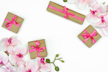Gift present boxes with pink ribbon, orchid flowers on white background. spring concept. Copy space