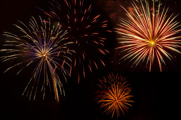 multiple bursts of colorful fireworks against black