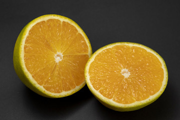 Fruta Laranja cortada no meio em fundo escuro
