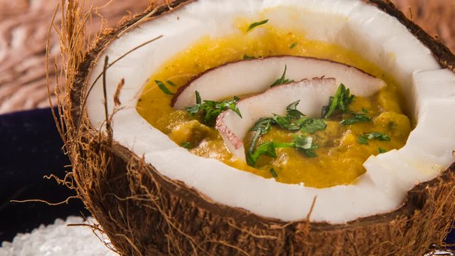 Slide shot Sururu soup inside a coconut with smoke. Brazilian dish