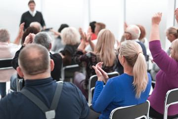 Audience of adult people listen to the speech of the lecturer
