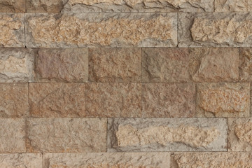 Wall made of yellow natural stone straight view