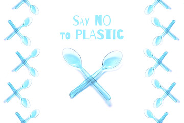 Isolated transparent pastel blue crossed spoons with text. Say no to plastic concept. Flat lay, top view.