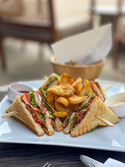 Lunch with a Club sandwich and french fries in the luxury Restaurant on the beach of the surin Phuket, Thailand