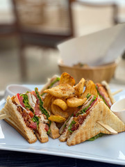 Lunch with a Club sandwich and french fries in the luxury Restaurant on the beach of the surin Phuket, Thailand