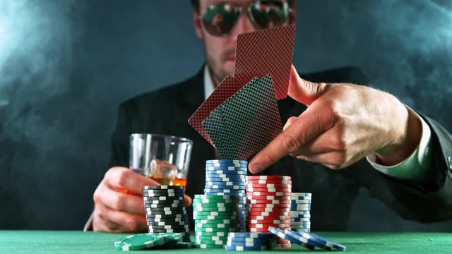 Poker player throwing cards towards camera, super slow motion, filmed on high speed cinema camera at 1000 fps. Gambling background.