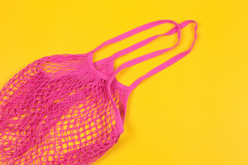 Reusable shopping bag on yellow background. Mesh cotton bag. Zero waste, plastic free concept. Top view, flat lay