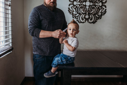 Midrange view of father taking young sons temperature at home