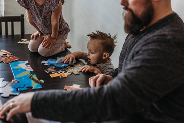 Family completing puzzle at home during isolation
