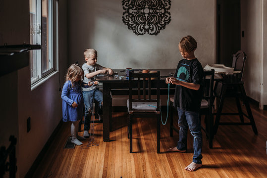 Siblings doing yarn project at home during isolation