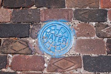 Water utility access cover on a brick street
