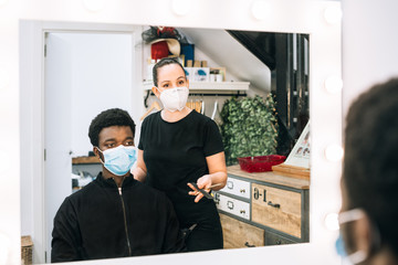 black guy in a hair salon with a coronavirus mask