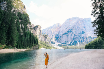 The girl in stylish dress and boater walk near Lake Lago di Brai