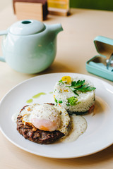 poached egg on steak with rice garnish