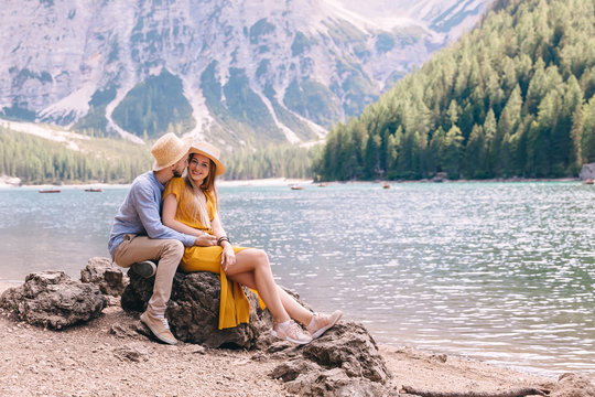couple in love hugging and sitting on snones by the shore of Lak