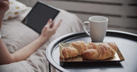Girl lying on bed having breakfast