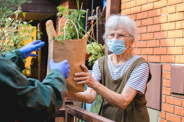 grocery delivery to senior woman during pandemic - Powered by Adobe