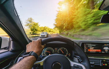 hands of car driver on steering wheel, road trip, driving on highway road