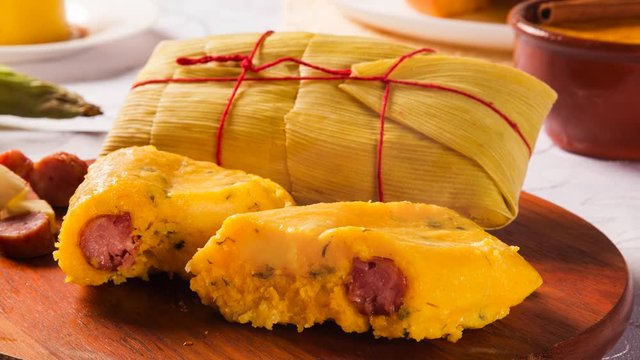 Slide shot Salty Pamonha with sausage and cheese - typical food of green corn - tasty and cheap - typical and popular street food with smoke.