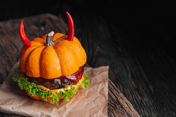 Burger Halloween. halloween concept of a burger with big beef patties with pumpkin head rolls for the holiday halloween