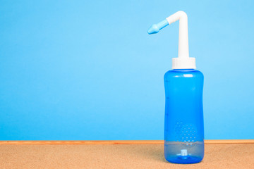 blue water pulse nasal wash bottle on a wooden table, nasal irrigation concept