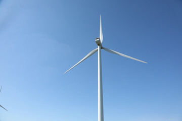 Windmill for electric power production, France. Blue sky