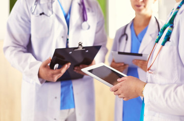 Doctors using a tablet in hospital standing in office