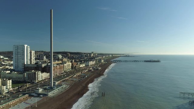 Stationary aerial shot of British Airways i360 structure with Brighton Palace Pier in background
