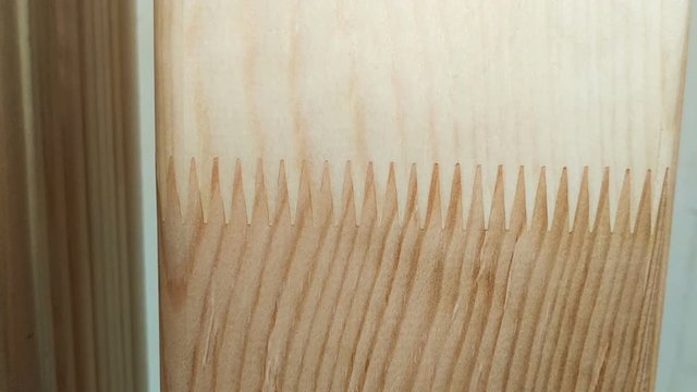 finger joint (mortise joint, mortise-and-tenon joint, joggle) of edged molded lumber. Fused wooden Board close up