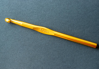 Gancho dorado para tejer lana.