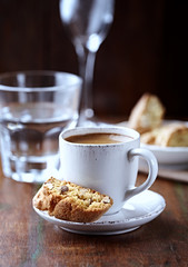 Cup of coffee with cantuccini (Italian cookies) on rustic wooden background.