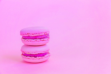 Fototapeta na wymiar Sweet almond colorful unicorn pink macaron or macaroon dessert cake isolated on trendy pink pastel background. French sweet cookie. Minimal food bakery concept Copy space