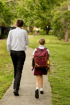 Father and daughter walking to school. NSW public school students to return to classrooms full time after coronavirus shutdown on 25th May 2020