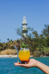 woman drinking orange juice on the beach