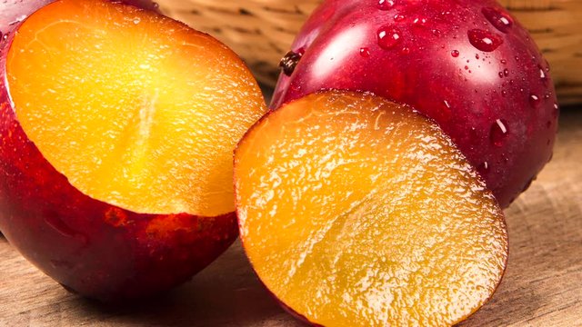 Fresh bright plums on wooden background