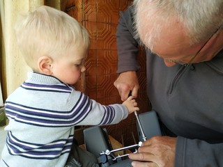 little boy helps grandfather in minor home repairs. Grandfather and grandson working together