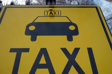Yellow Taxi sign with pictogram of a car