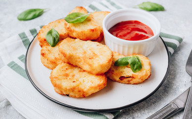 Hash brown or potato pancakes on plate with catsup on light gray background