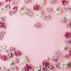 Floral pattern made of lilac flowers on pink background. Flat lay. Floral purple frame