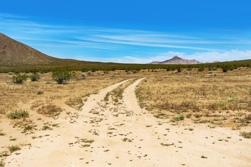 Dirt road in an open land in the Mojave Desert in the Apple Valley area in California.