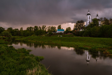 Fototapeta na wymiar Orthodox Church by the river in the evening sunset