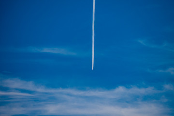 Lines of planes in the blue sky that mix with the clouds and form interesting figures. Background