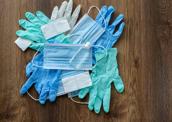 protective equipment against COVID-19, medical masks, rubber gloves, disinfector, on a wooden background